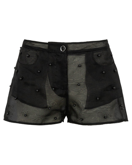 Black shorts with sheer panels and button details on a white background