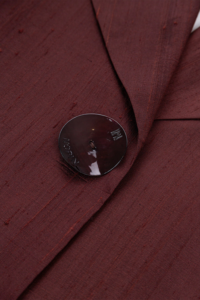 Close-up of a button on a burgundy fabric