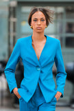 Woman wearing a bright blue suit with a blurred background
