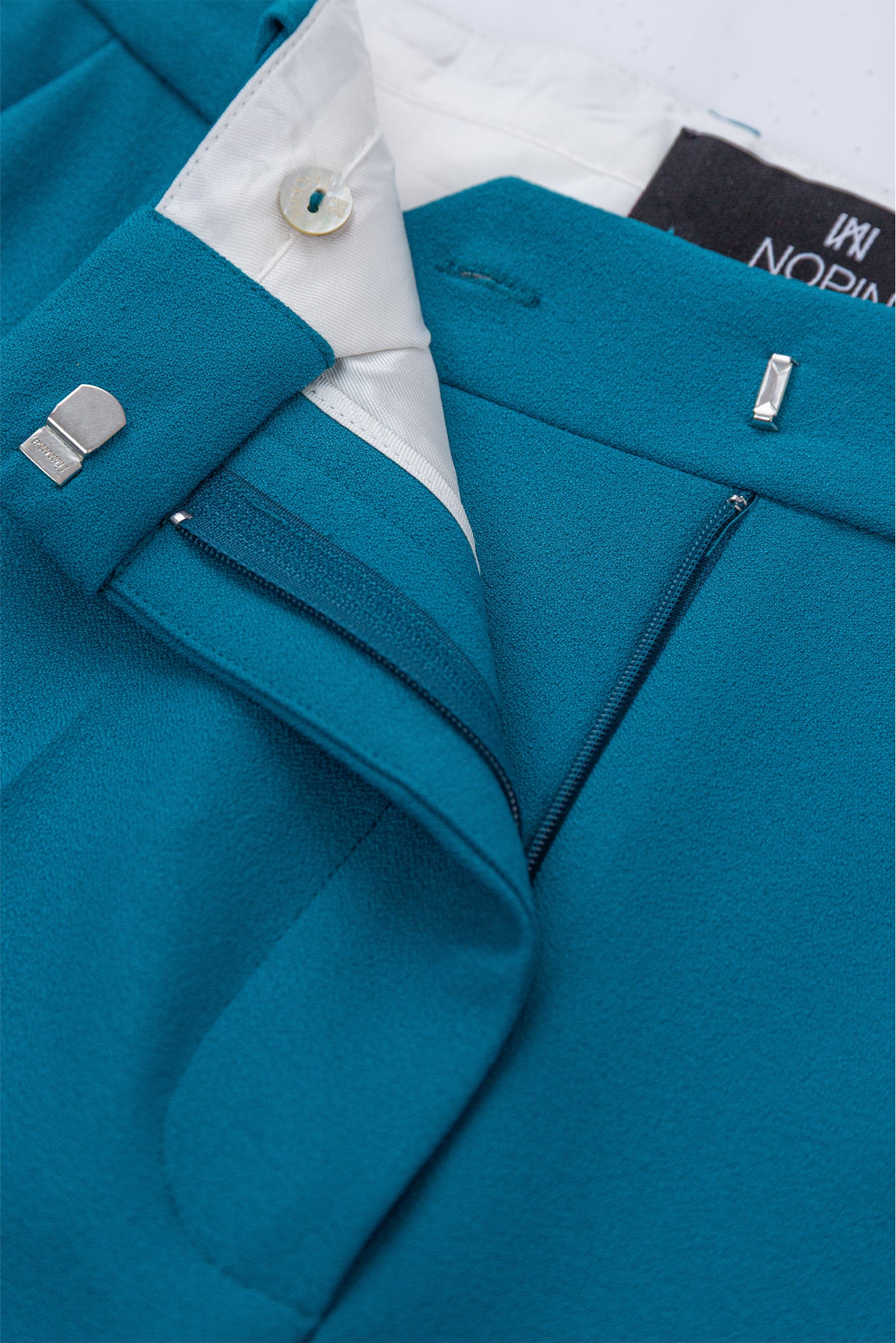 Close-up of a blue jacket with a brand label on a white background