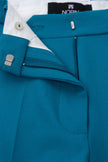 Close-up of a blue suit with white shirt and visible brand name on cufflinks.