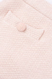 Close-up of a textured pink fabric with a button