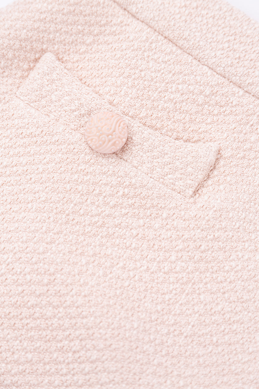 Close-up of a textured pink fabric with a button