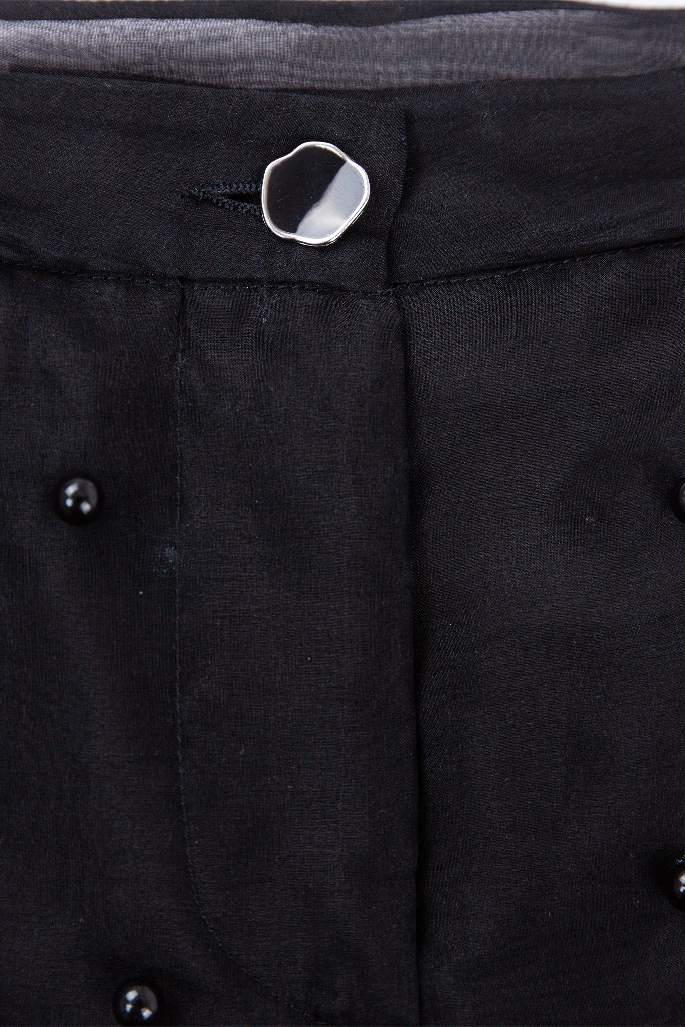 Close-up of a black coat with buttons on a dark background