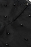 Close-up of a black coat with buttons on a plain background