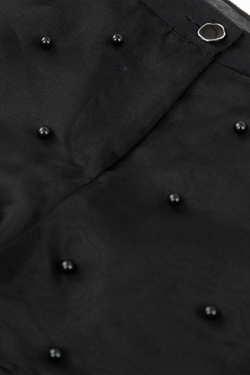 Close-up of a black coat with buttons on a plain background