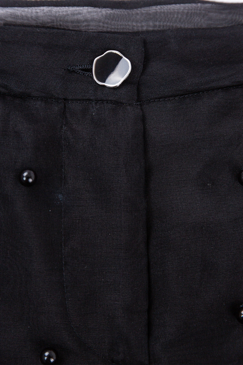 Close-up of a black coat with buttons on a dark background