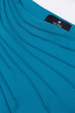 Close-up of a blue garment with a visible brand label on a white background