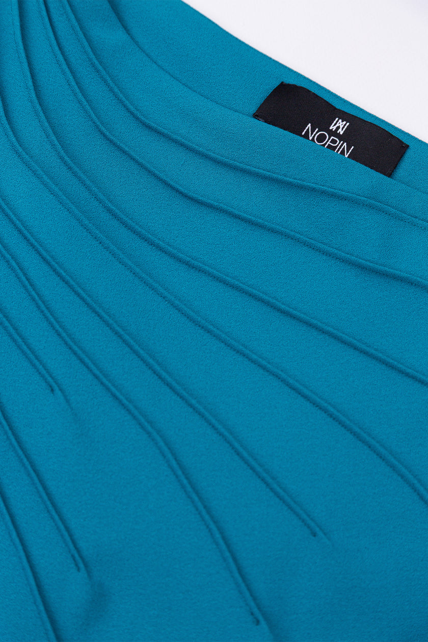 Close-up of a blue garment with a visible brand label on a white background