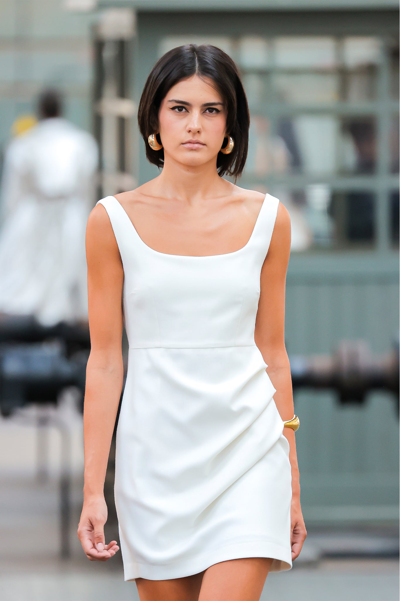 Woman wearing a white dress standing in an urban setting