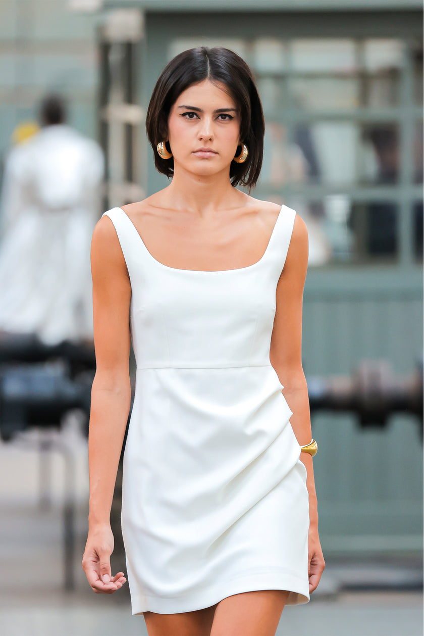 Woman wearing a white dress standing in an urban setting