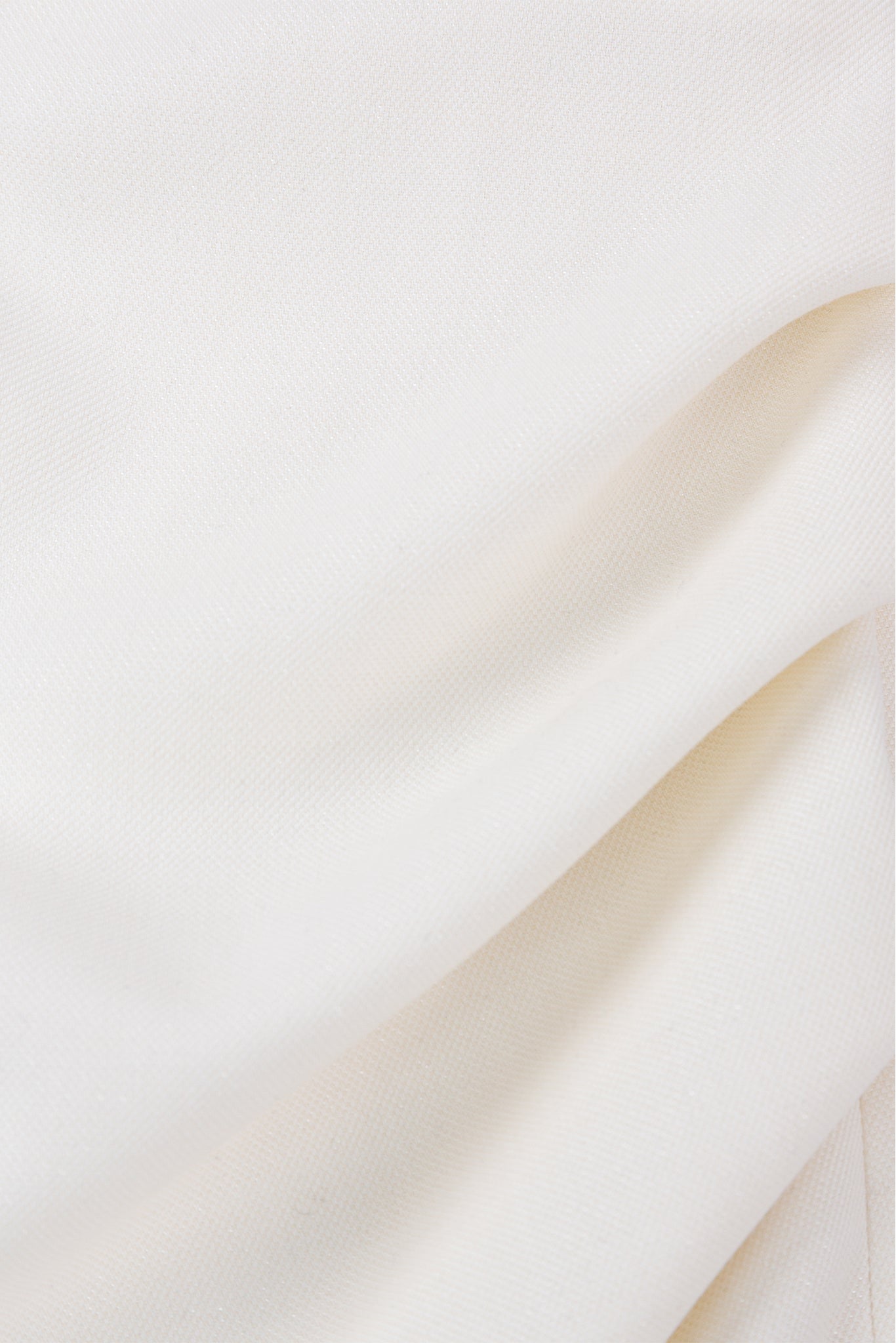 Close-up of beige fabric with a subtle texture on a light background