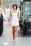 Woman in a white dress walking in an urban setting