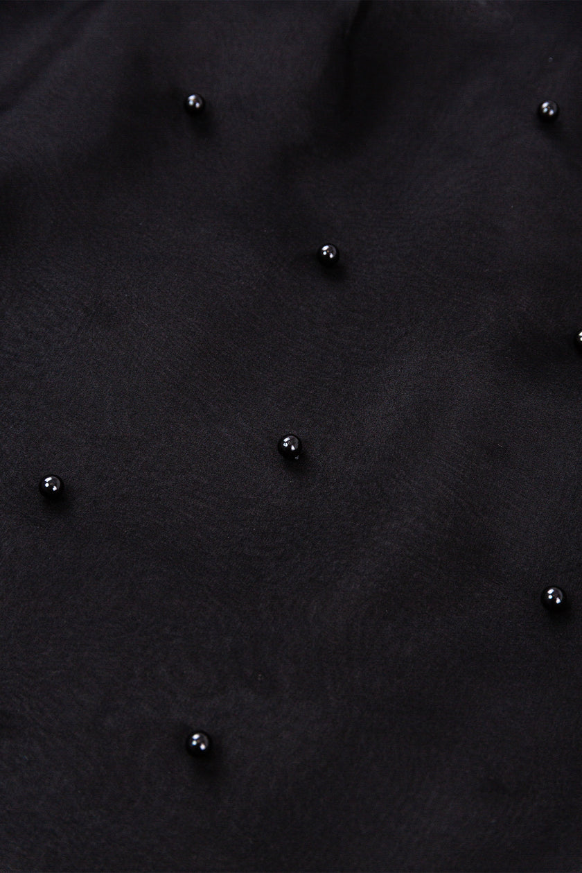 Close-up of a textured black surface with small black beads.
