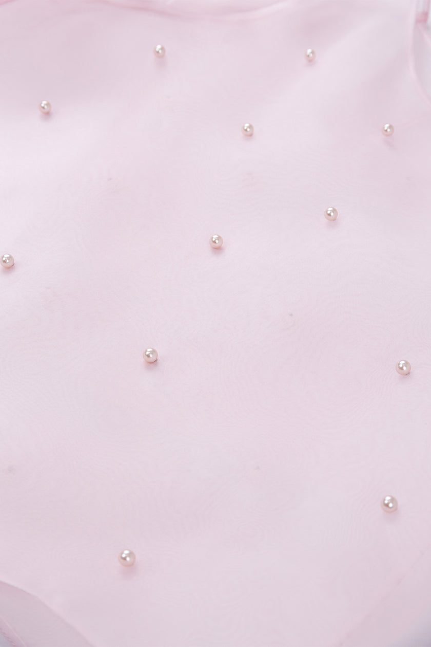 Close-up of a light pink fabric with small pearl-like embellishments.