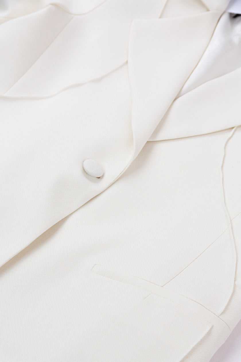Close-up of a white suit jacket with a button