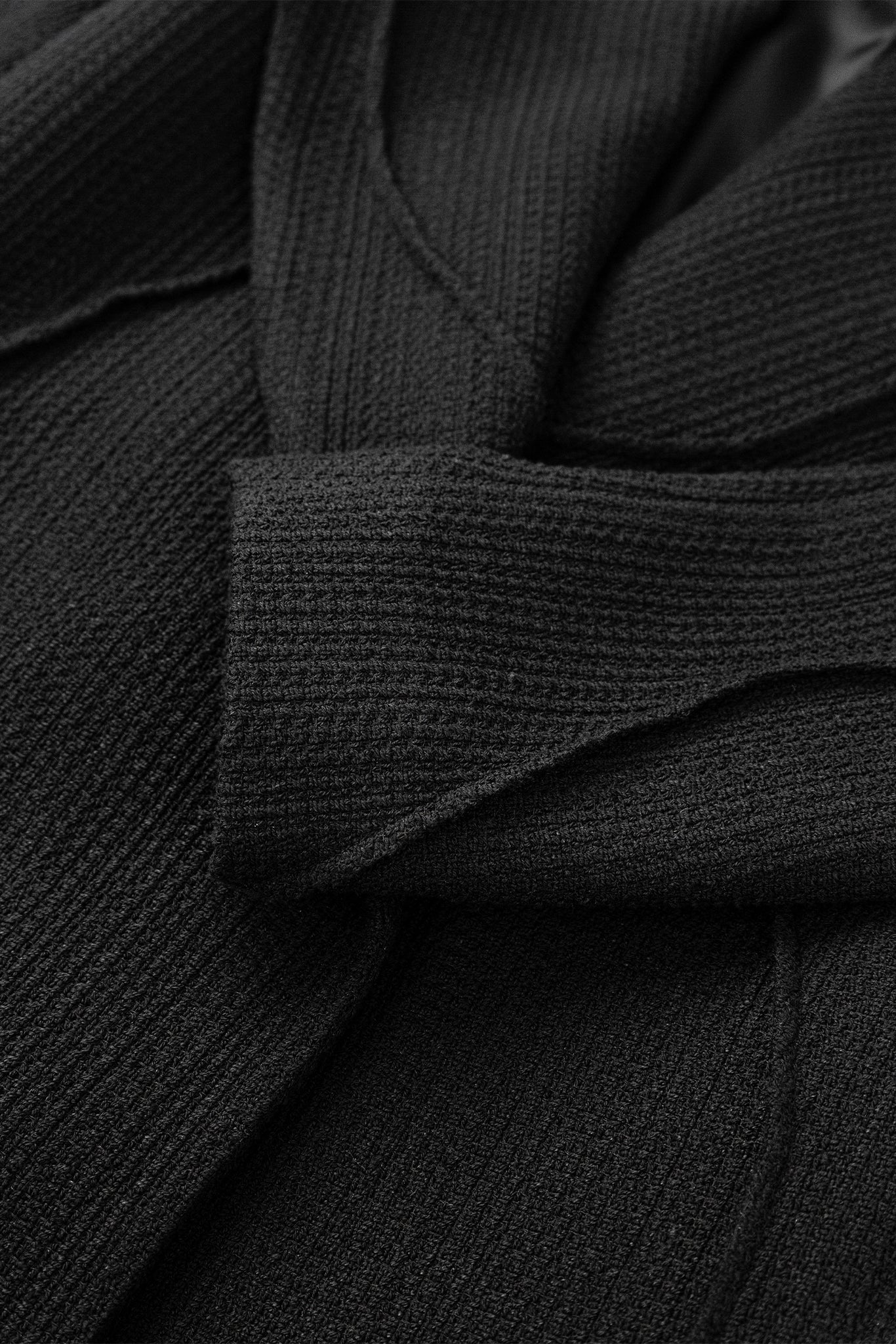 Close-up of a black textured fabric with a focus on texture and color.