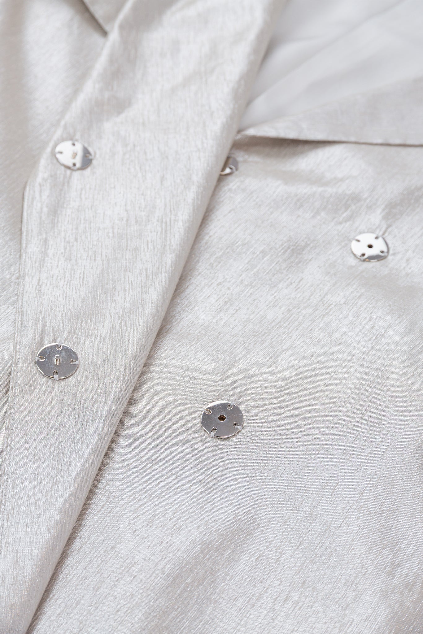 Close-up of a light gray textured fabric with buttons