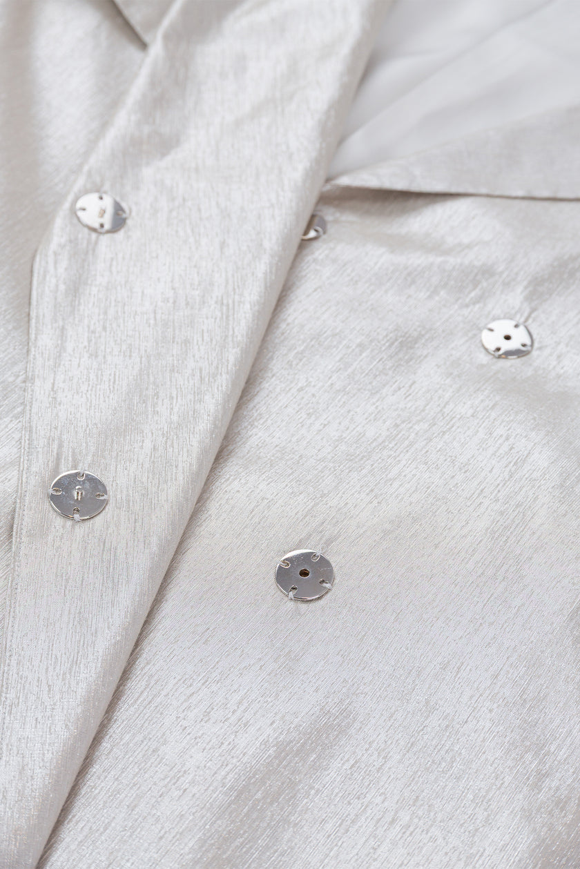 Close-up of a light gray textured fabric with buttons