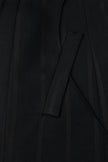 Close-up of a black garment with a pocket detail