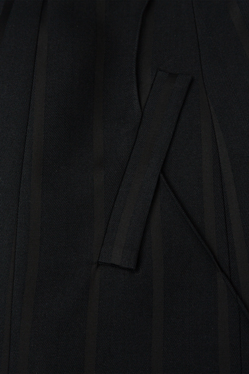 Close-up of a black garment with a pocket detail